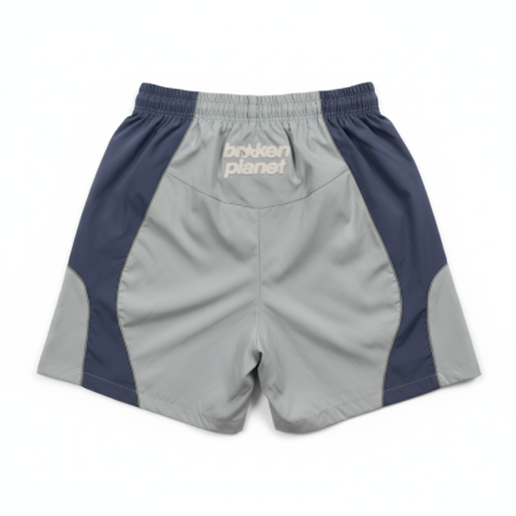 BROKEN PLANET COLOR BLOCK WIND SHORTS LIGHT BLUE NAVY - back white background flat lay
